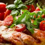 9456514-a-fette-di-pizza-con-rucola-e-pomodorini-sul-tavolo-in-legno